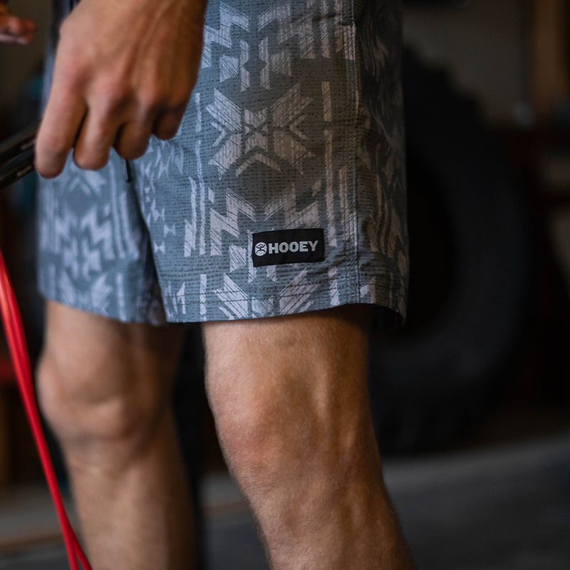 male model wearing the Bigwake grey and white Aztec pattern board shorts