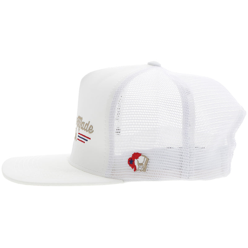 the left side of American Made Cap Co hat in white with red, blue, and gold embroidered details