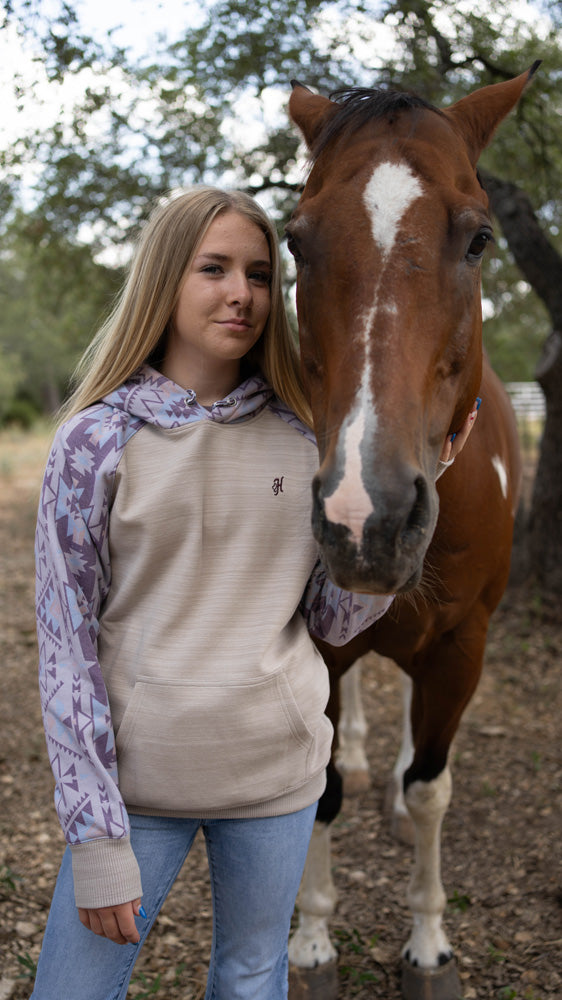 teen sporting light wash jeans with cream/white/grey Aztec hoody with red and white horse