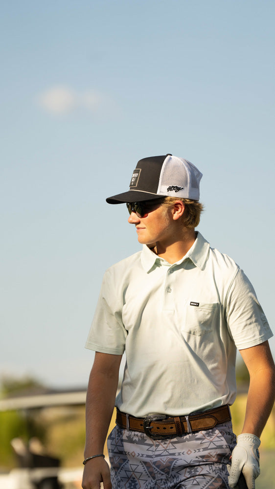 male model posing in white golf polo