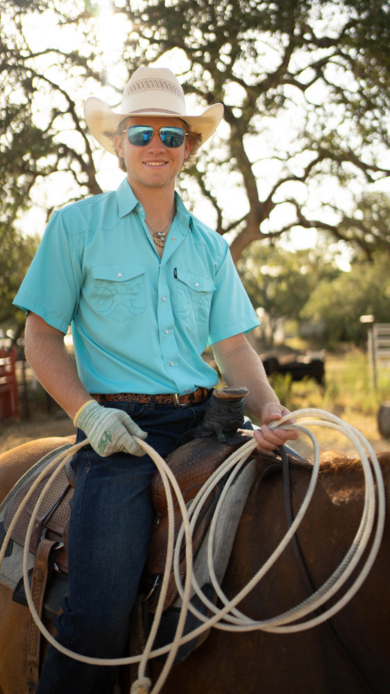 male model wearing dark wash jeans while seated horse back