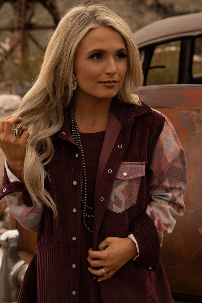 close up of female model wearing burgundy corduroy jacket with aztec pattern sleeves and jacket