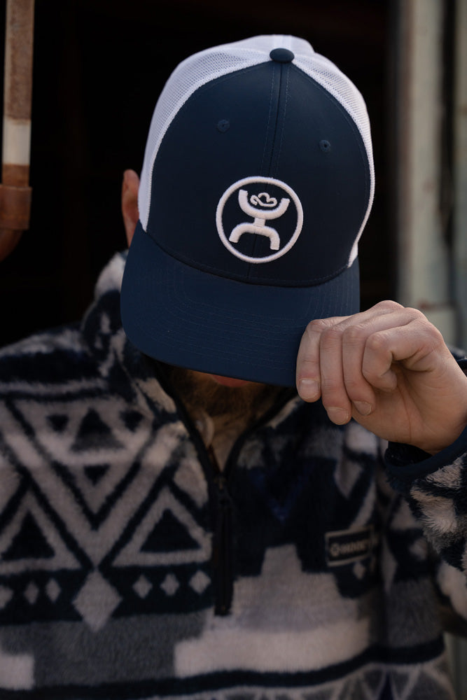 male model wearing navy an white cap, with navy and white fleece pullover