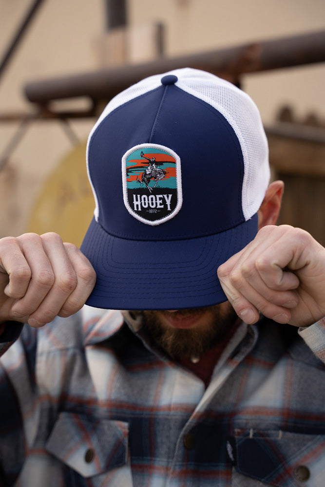 male model wearing navy and white Cheyenne hat with grey and white plaid shacket