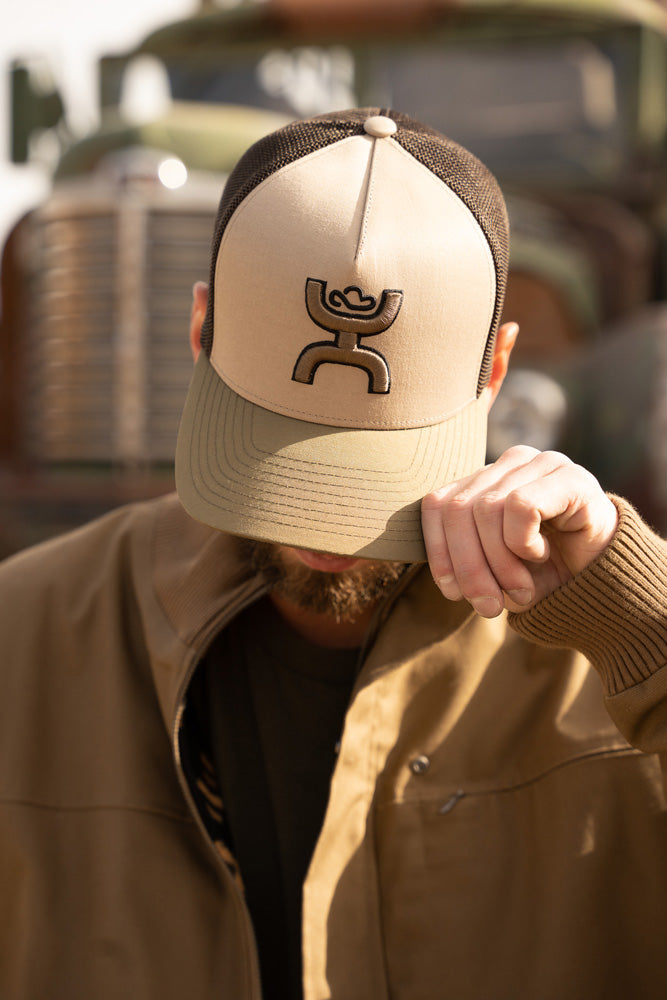 male modeling tan jacket with tan, brown, olive hooey hat