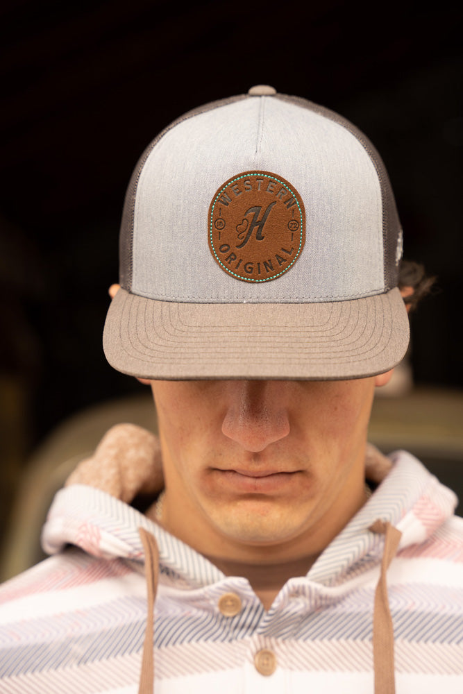 male model wearinf pink, grey, tan serape hoodie with grey and tan hooey hat