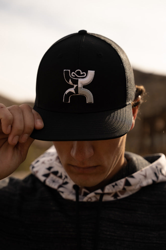 male model wearing black hoody with white and black aztec pattern hood, and black on black hooey hat