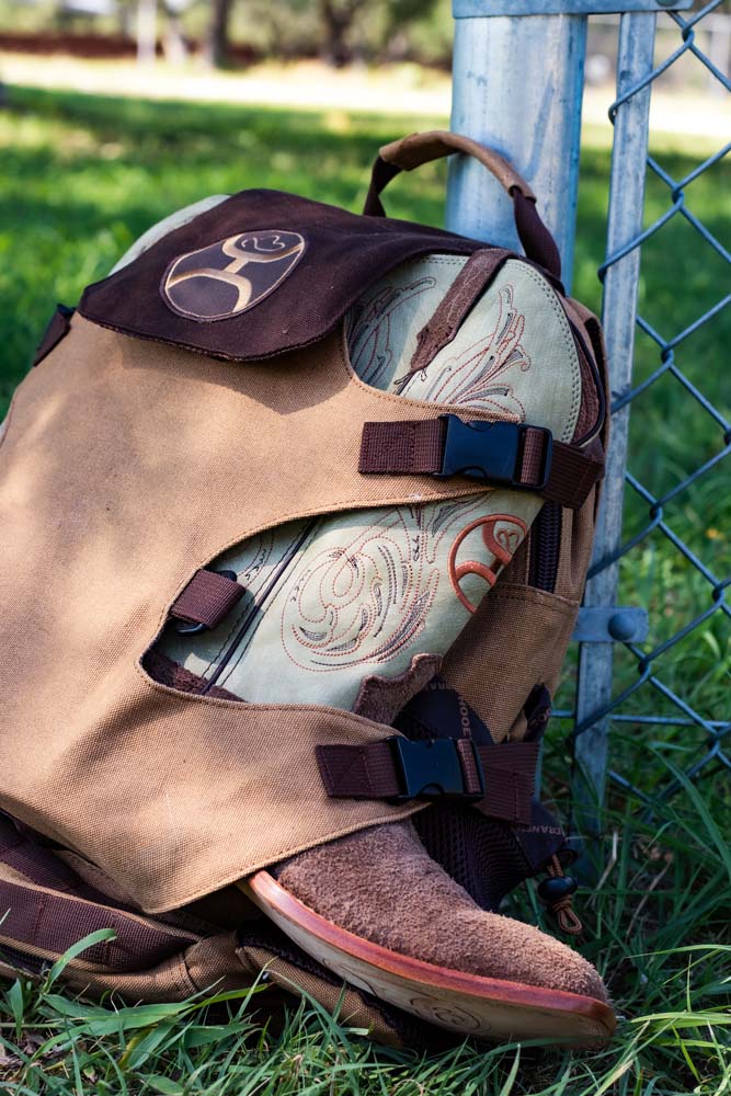 photo of the Mule tan and brown backpack with a pair of tan and brown Hooey boots in the boot straps