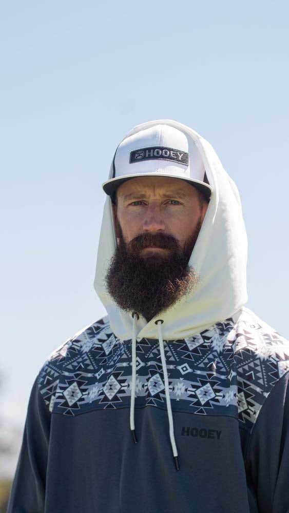 male model wearing the Ridge Hoody in white and denim with aztec pattern on the collar and white hood with the hood up