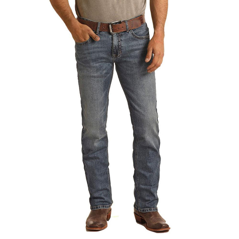 front view of the Medium Vintage Reflex Revolve Slim Straight Hooey jeans on male model wearing brown leather belt, tan tee, brown leather cowboy boots