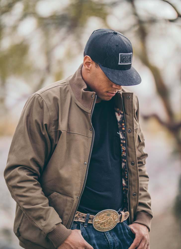 male model wearing the Hooey Cargo Jacket in tan with Aztec pattern lining in outdoor setting