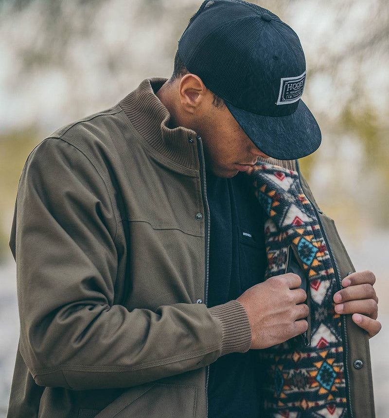 male model wearing the Hooey Cargo Jacket in tan with Aztec pattern lining in outdoor setting