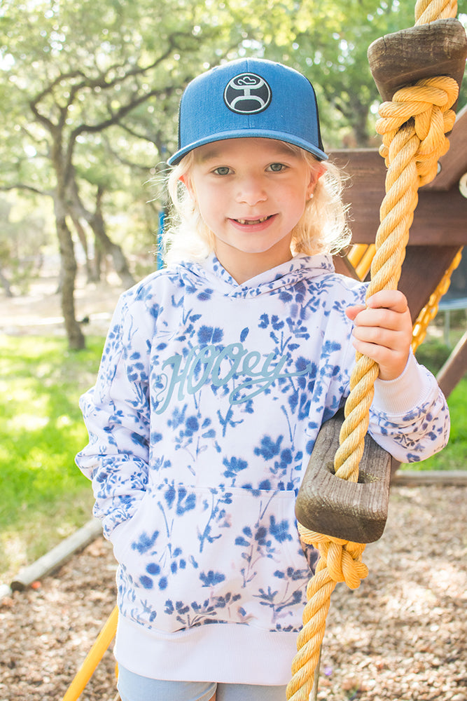 young model wearing the youth canyon blue floral print hoody with blue logo